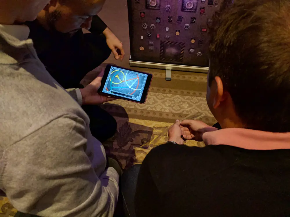 Équipe jouant à l’escape game sur iPad La Machine Infernale