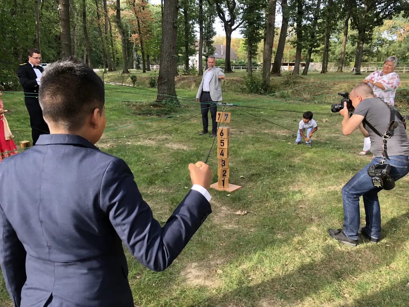 Invités jouant à la Pêche aux cubes, jeu coopératif géant en bois, dans un parc